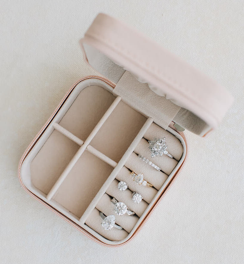 jewelry box full of diamond custom engagement rings and luxury custom rings as well as diamond earrings and a diamond band
