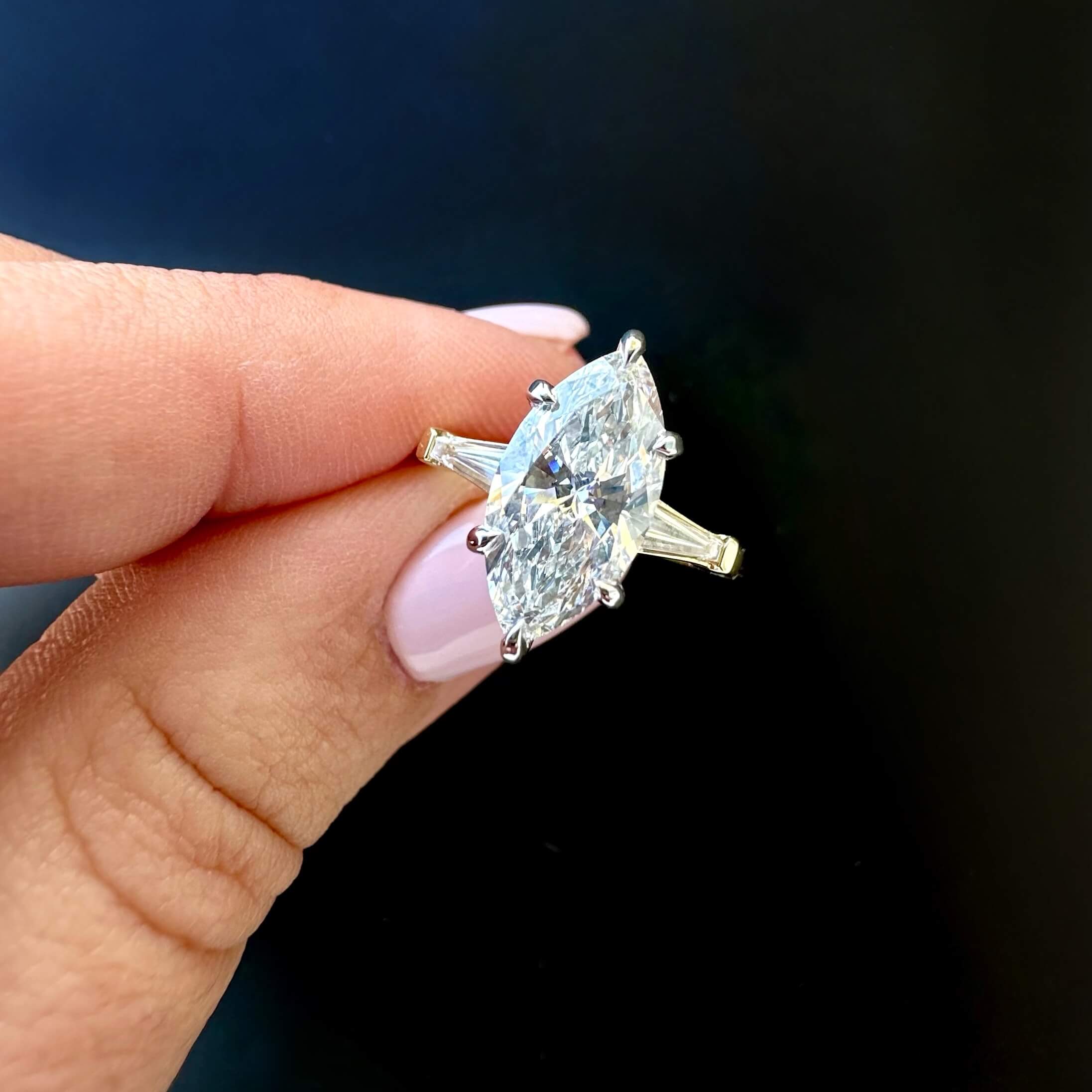custom 2 carat marquise lab grown diamond with a hidden halo and custom diamond tapered baguettes in a 14k yellow gold wedding band