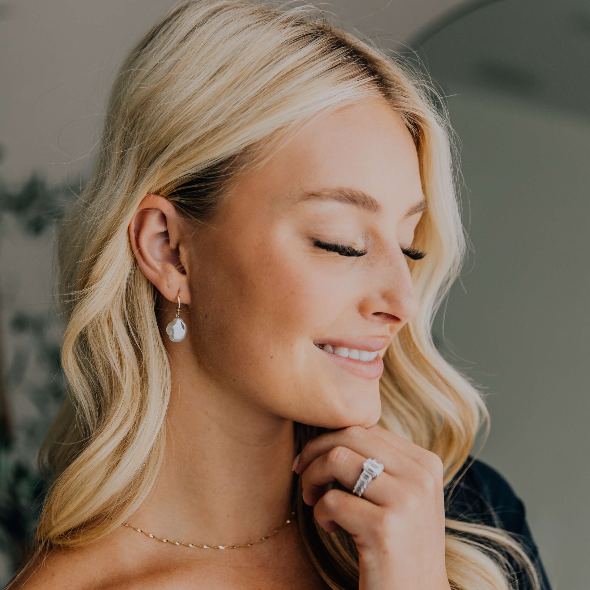 woman with organic pearl dangle earrings and other fine jewelry.