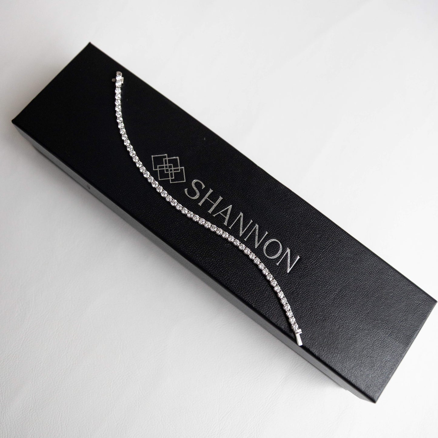 Jewelry box with a 14k white gold tennis necklace and 'SHANNON' branding on a white background