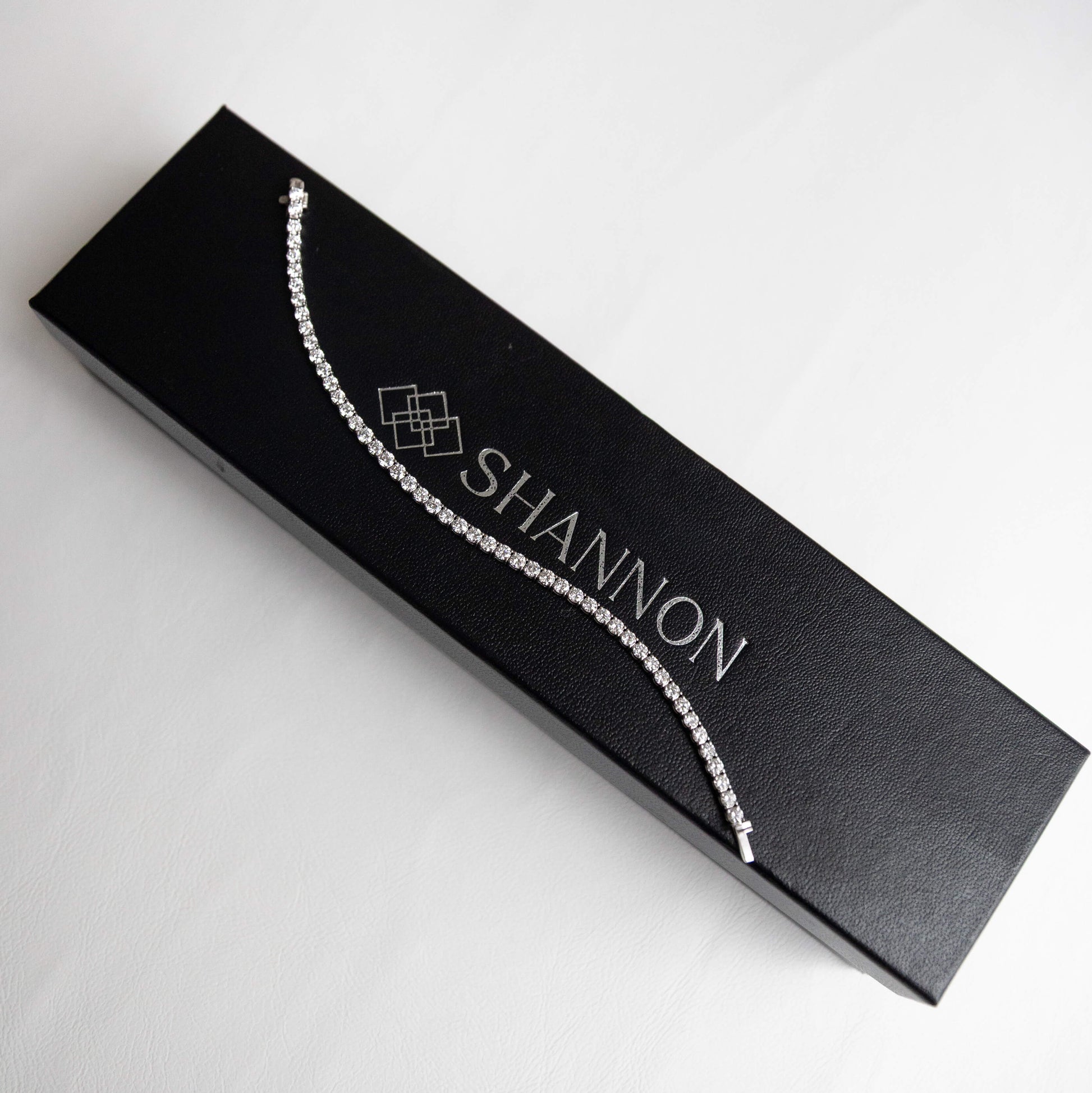 Jewelry box with a 14k white gold tennis necklace and 'SHANNON' branding on a white background