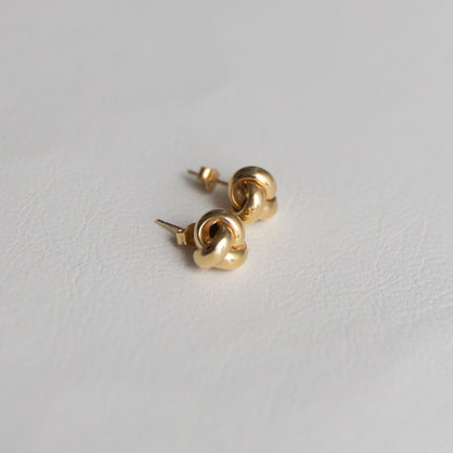 14K Gold love knot earrings on a light gray background