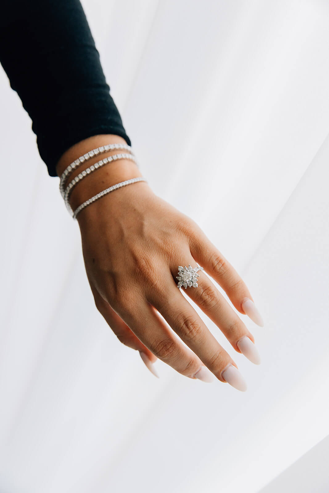 two carat natural round diamond in a custom engagement ring with lab grown diamond tennis bracelets