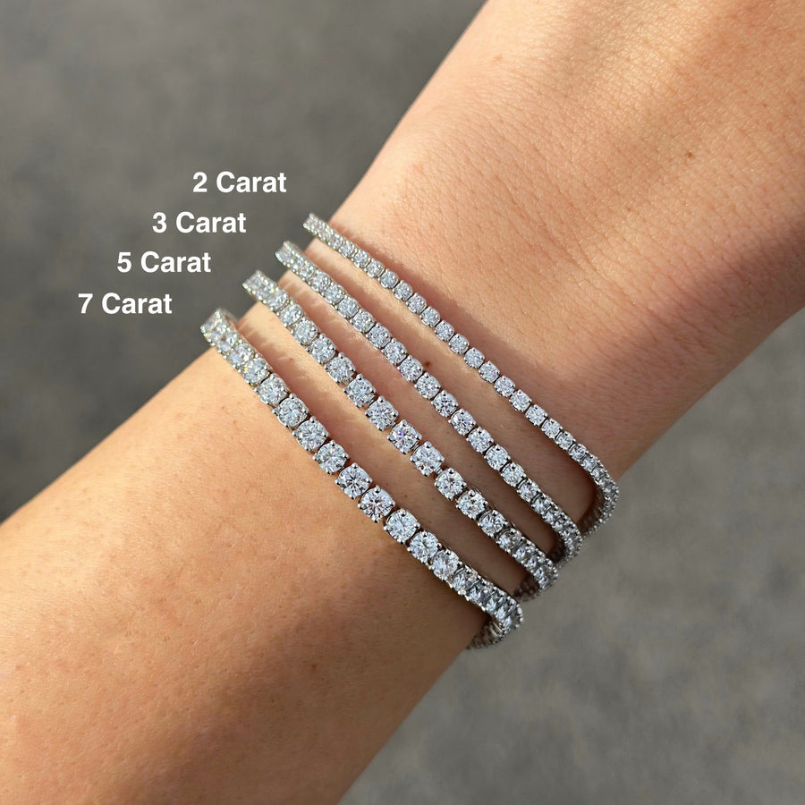 14k white gold tennis bracelets on a white woman's arm with a gray background. 2, 3, 5 and 7 carat bracelets. 