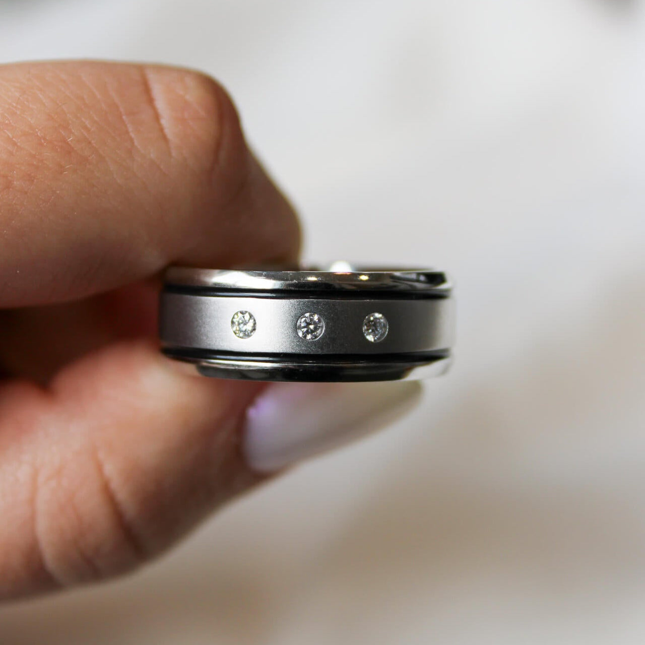 Cobalt chrome mens band with 3 lab grown diamonds and a two black inlays against a white background.