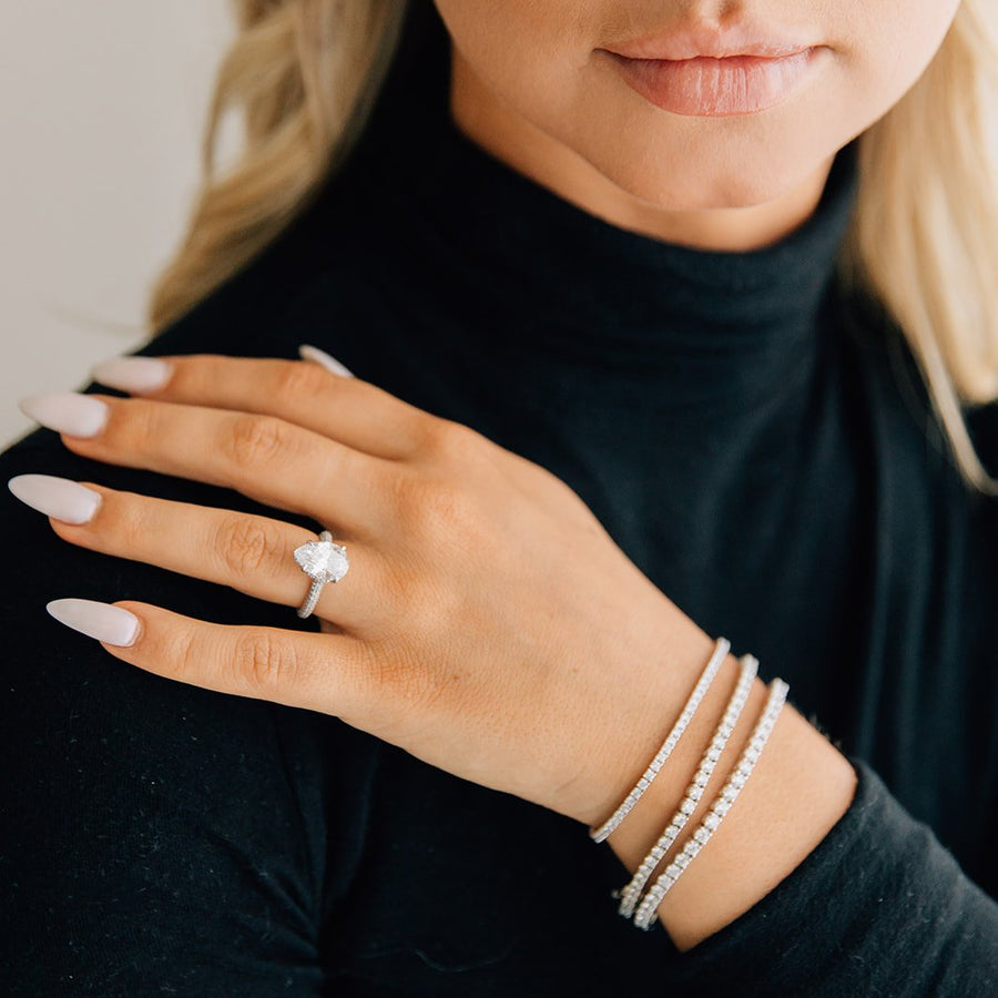 three carat lab grown diamond pear with a hidden halo and triple pave band and three lab grown diamond tennis bracelets